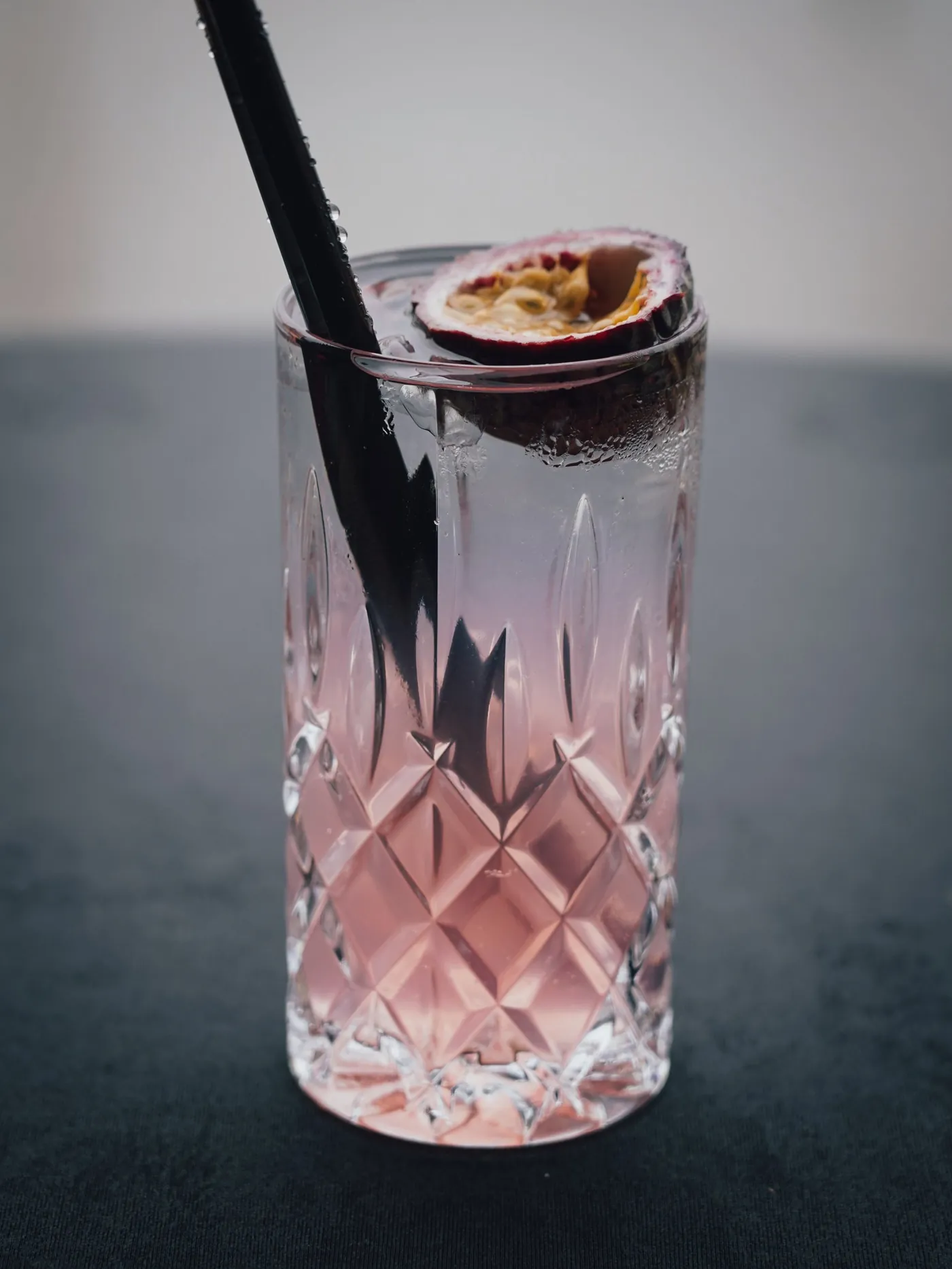 Rosa Longdrink im Kristallglas mit Passionsfrucht